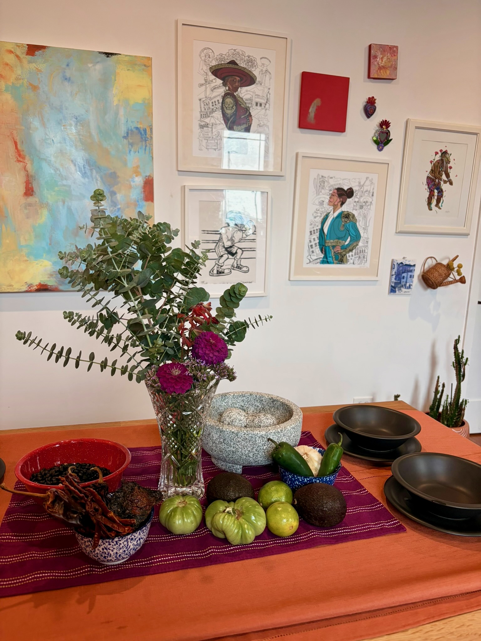 Kitchen worktable prepared with produce, flowers, and a traditional molcajete